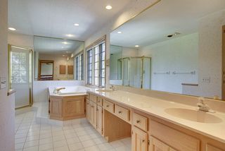 Large Master Bath with His and Her's vanities, sit down area for make-up, tiled floors, separate shower and tub deck area.