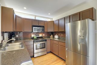 The Kitchen features Granite Countertops, Glass Tile Backsplash & Stainless Steel Appliances