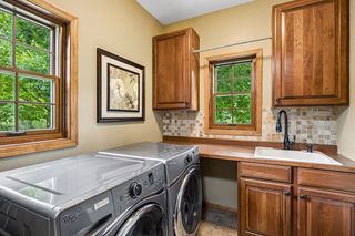 Laundry Room with Ceramic Tile flooring and backsplash, cabinets and stainless washer/dryer