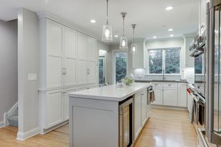 Striking kitchen has enameled cabinetry and a full wall pantry