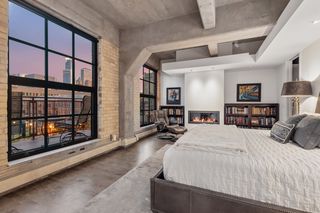 Inviting primary suite with gas fireplace and city skyline views.