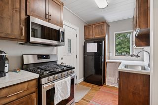 View of Kitchen in Apt #4.
Features Custom Birch Cabinets, Stainless Steel Appliances, Custom Stained Hardwood floors, Shiplap Ceiling and Lighting.
Rear entrance walks out to private porch.