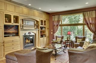 Hardwood flooring in the great room, granite fireplace, large windows and wooded views