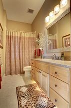 Main floor full bath with granite vanity, under cabinet lighting and linen cabinet