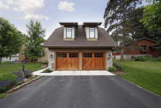 Dormers off master bedroom, western red cedar garage doors by designer doors. Natural stone exterior.