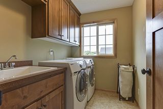 upstairs laundry with beautiful cainetry, laundry sink, and natural light.