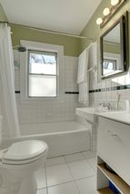 The charming Bathroom features Ceramic Tile Floors & Tile Surround