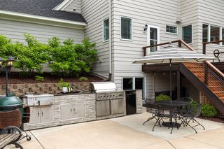 Outdoor kitchen area with stainless steel, granite, sink, and min refrigerator