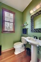 1/2 Bath off the Entry hallway. Pedestal sink with dark bronze fixtures.