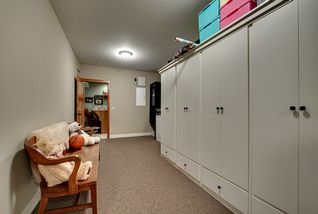 Large finished storeroom, carpeted, with numerous built-in finished cabinets.