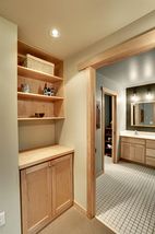 Cabinetry provides storage for lower level bath towels and supplies