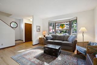 Sunny and bright front windows bring light into the living room with wood burning fireplace