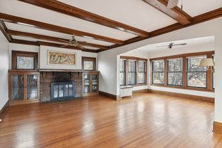 spacious living room with wood burning fireplace and sunroom