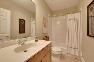 The full bath features tile floors and and a tile surround.