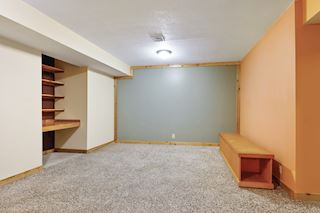 Large family room on lower level with built in desk & shelves