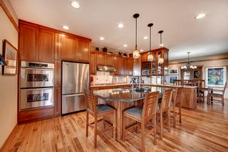 A double wall oven for baking and convection. Large 5 burner cooktop with ceramic tile backsplash.
