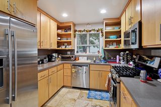 Another view of kitchen.
Updated kitchen features Stainless Steel appliances and Custom Maple cabinets, Travertine Tile flooring and a built-in pantry.