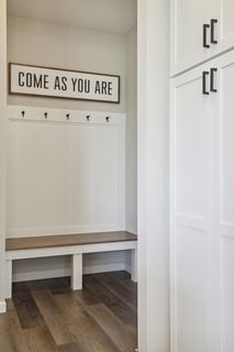 A wooden bench with coat hooks in the mudroom 
makes for a pleasant homecoming after a busy day.
