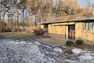 A paver patio with perennial gardens and a retractable awning
