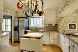 The Light-Filled Kitchen features Hardwood Floors & lots of Cabinets...