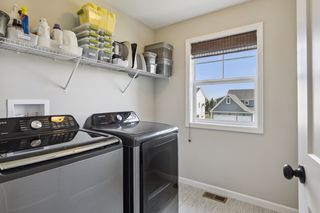 A smart, upper level laundry features a matching washer, dryer and
 a viewing window.