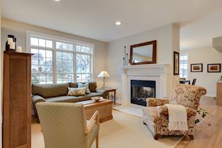 Large floor to ceiling windows and a fireplace to create a warm, cozy gathering spot