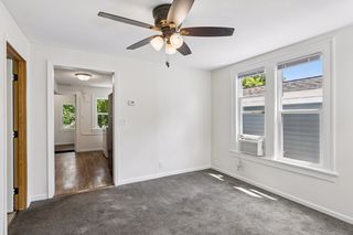 Upper unit living room with ceiling fan and window unit AC