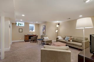 Lower level family room and alcove for an office with egress window for light