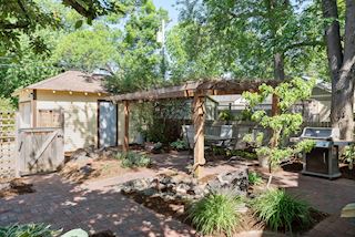 Beautifully landscaped backyard with paver patio and pergola leads to one car garage 