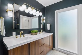 But the real highlight is your private primary bath with huge frosted window bringing in a private natural light and gorgeous dual sink teak vanity