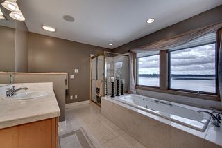 Separate vanities, whirlpool tub, heated floors, large glass shower complete this owners bath.