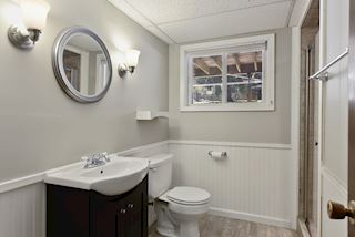 Three-Quarter lower level bath beautifully renovated awash with light and view of the large back yard.