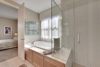 The master bath also features jacuzzi tub and separate shower with glass walls and tile surround.