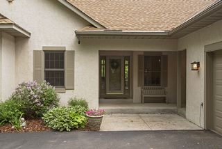 The beautiful landscaping and covered porch greets you as enter this lovely home