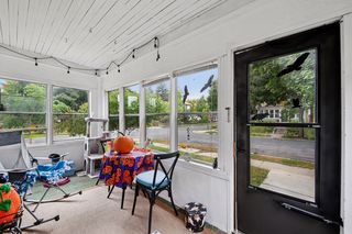 Single family front porch features beadboard ceiling and hardwood floors.