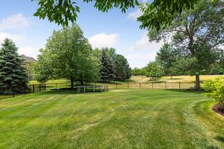 Fenced in flat backyard with a trampoline
