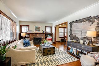 Living Room with lots of light, brick wood burning fireplace flanked by built in bookcases