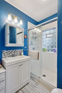View of Updated Bathroom in Apt #.
Newer Shower surround, Tile in shower and on floor, Vanity, Toilet, Sink, Faucet, Med Cabinet. Lighting & Glass block window.