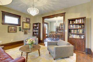 The Living Room features Hardwood Floors, Rich Woodwork & Crystal Chandelier! 