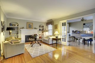 The Gracious Living Room features Hardwood Floors, Fireplace, Coved Ceilings & Original Built-In's...