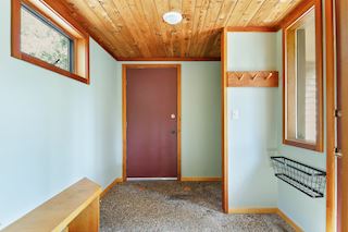 Entry from garage with door to back deck features exposed aggregate floors