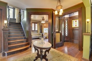 The Grand Entry Hall features Period Lighting, Hardwood Floors, Stained Glass Window and Staircase to the 2nd Floor...