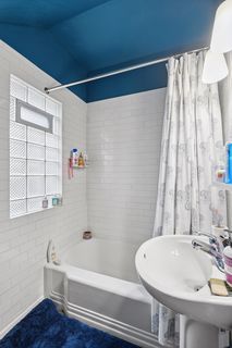 View of Bathroom in Apt #2.
Features Subway Tile and vinyl flooring.