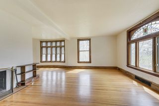 The entertainment sized Living Room features Huge Windows & Hardwood Floors...