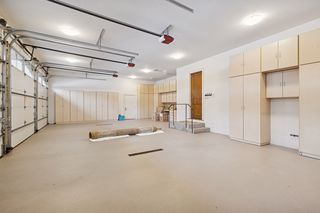 Fabulous oversized 4 car garage is heated, epoxied floor, 4 drains,  workbench, package room, and a lot of storage!