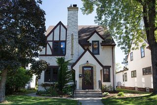 Stucco 2-story, with Tudor detail, 4 light windows, stone accents, cement sidewalks and entry steps.