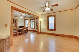 The Living Room features Gleaming Hardwood Floor, Rich Woodwork & Ceiling Fan! 