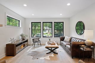 Trendy black-frame windows and hardwood floors with matte finish
