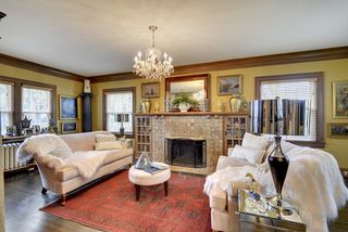 The large Living Room features Original Crown Moldings, Gleaming Hardwood Floors and Fireplace surrounded by Built-In's...