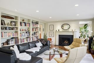 Wall of bookcases and wood burnng fireplace completes the elegant and inviting living room